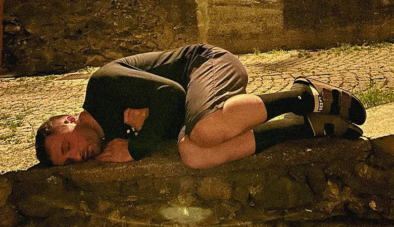 Rider asleep curled up on the ground