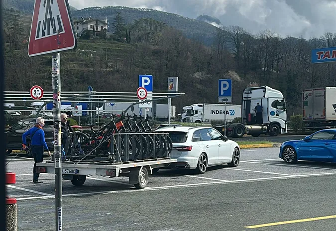 Car with a trailer full of bikes at a service area